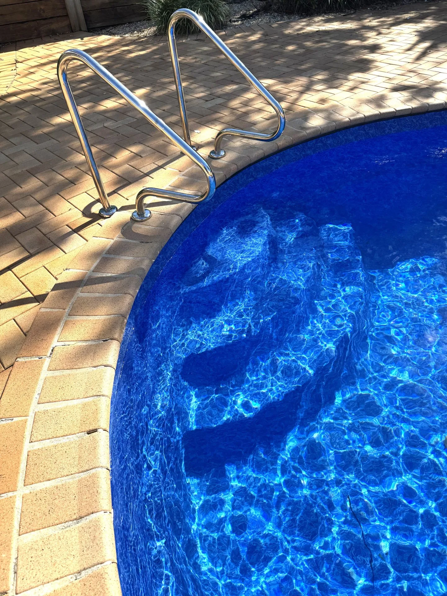 Light coloured vinyl pool liner for bean shaped swimming pool.
