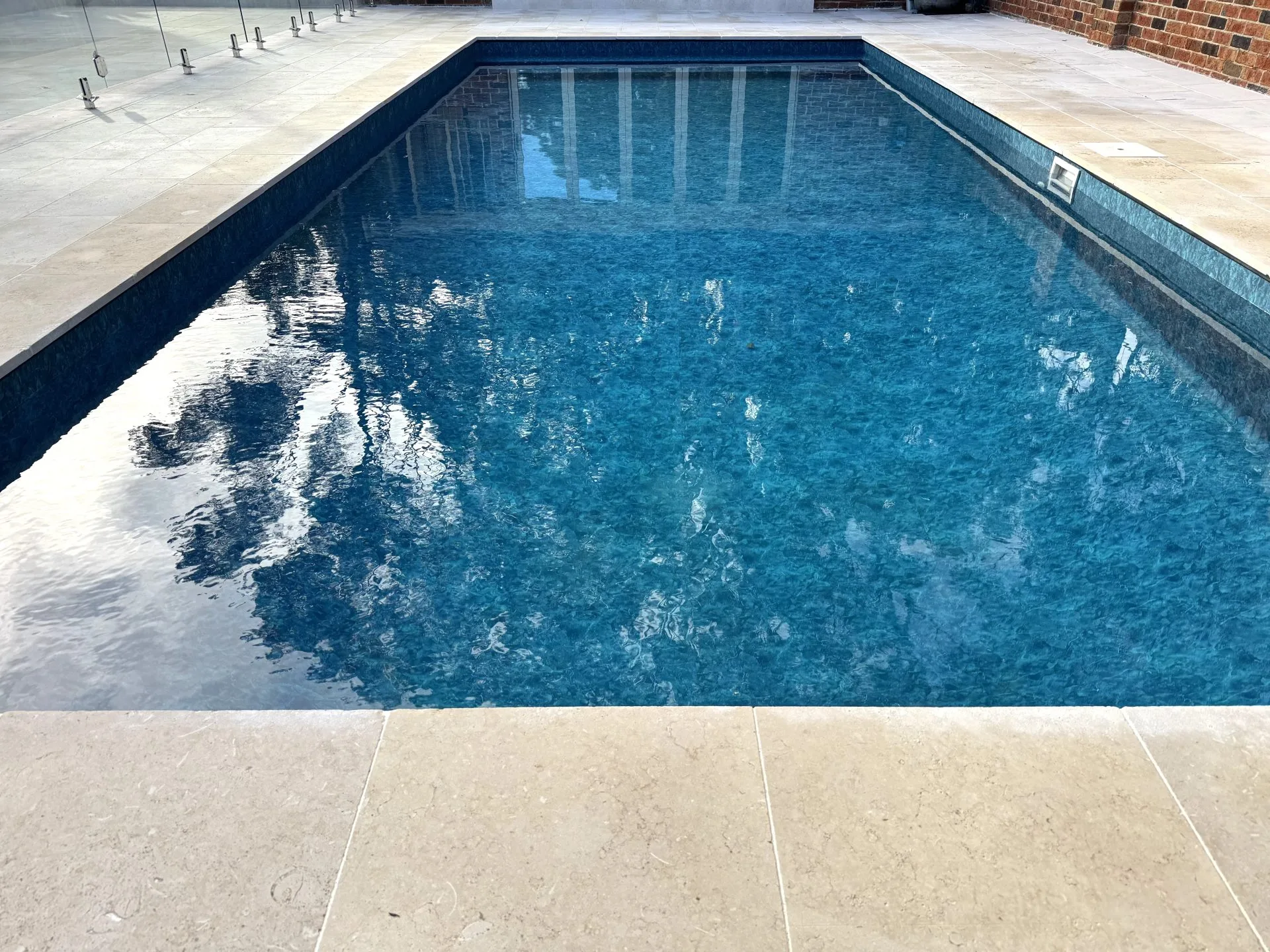 Stunning blue swimming pool and spa in gorgeous outdoor area.