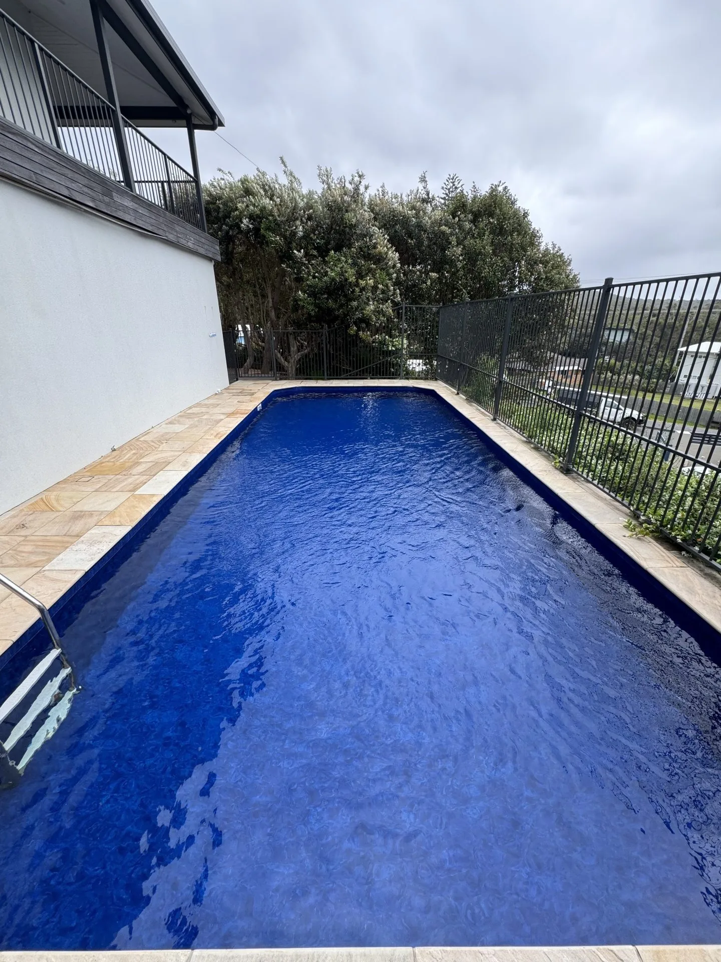 Stunning blue swimming pool and spa in gorgeous outdoor area.