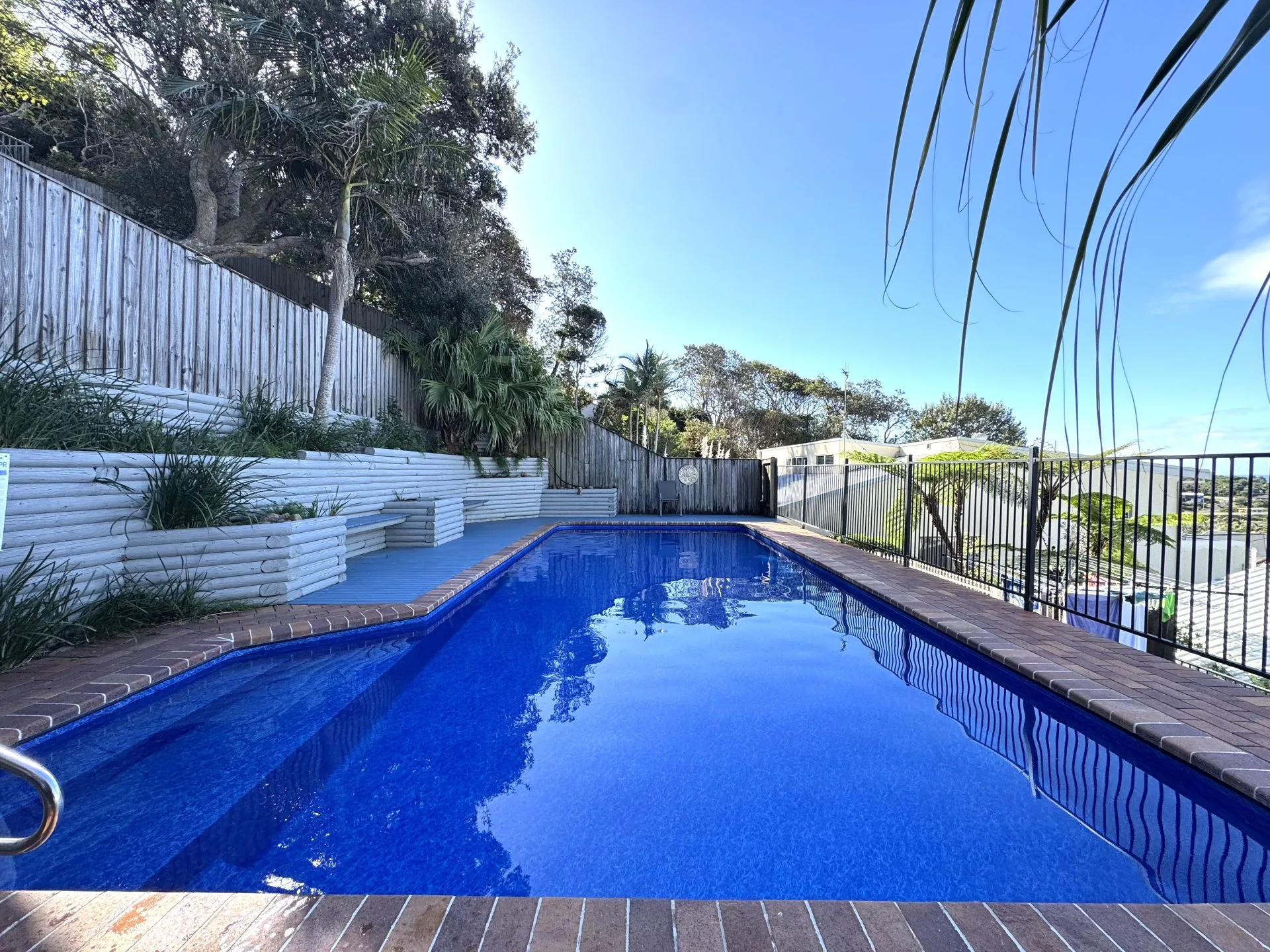 Blue vinyl pool liner for swimming pool and backyard tropical retreat.
