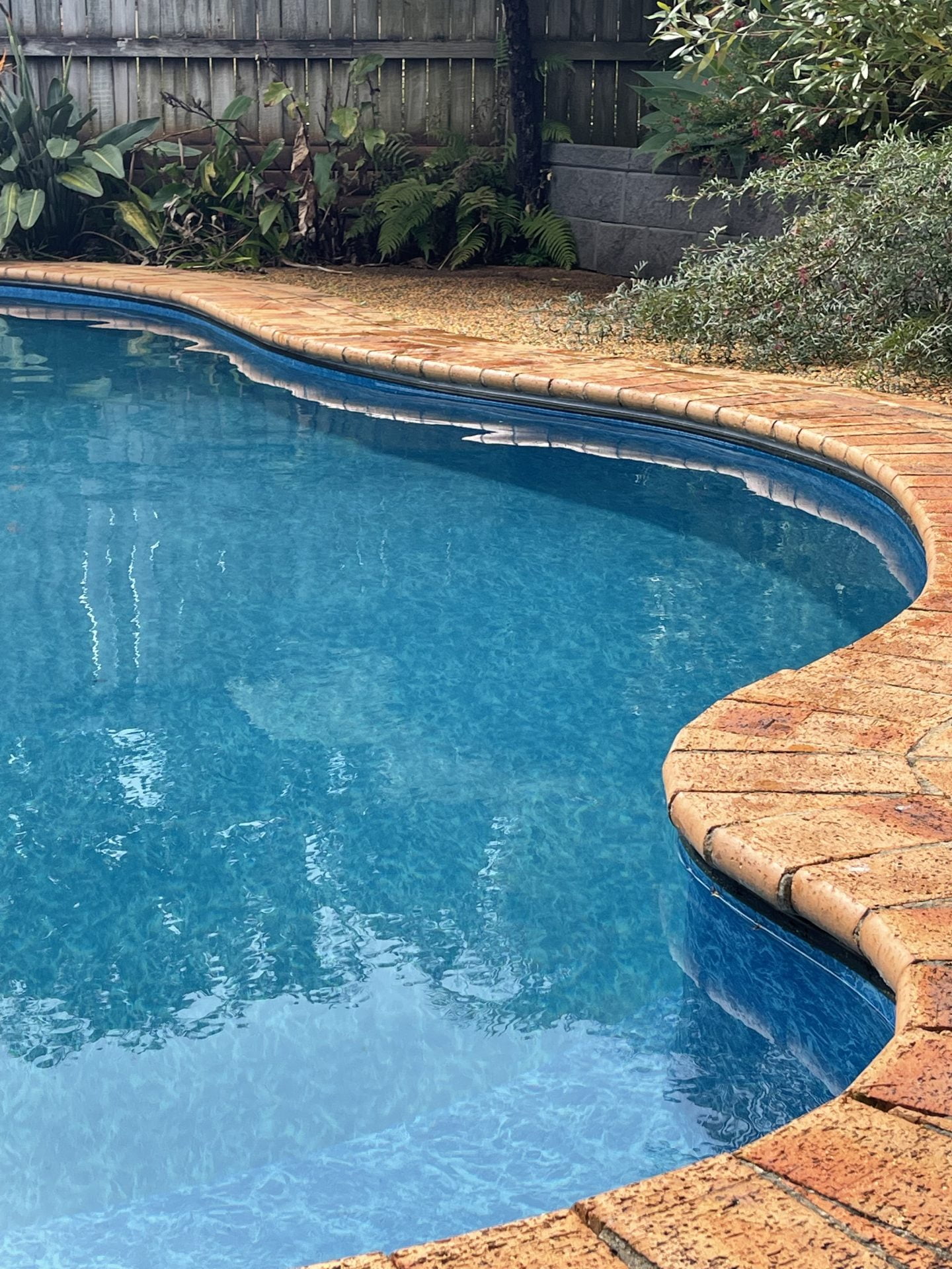 Light coloured vinyl pool liner for bean shaped swimming pool.