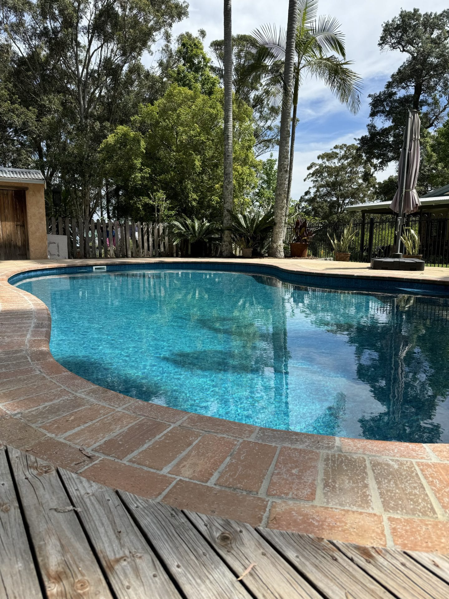 Light coloured vinyl pool liner for bean shaped swimming pool.